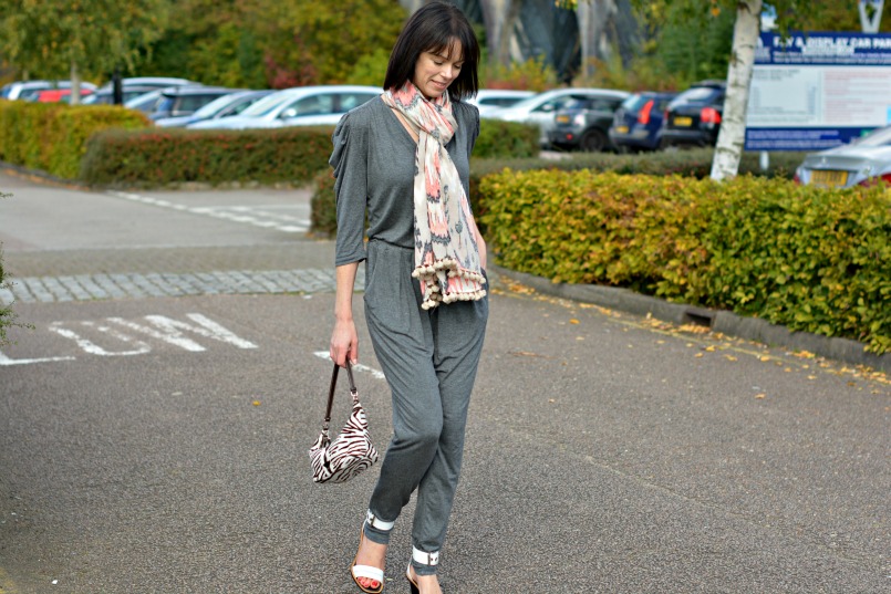 Sandro grey jumpsuit | Prada zebra pony hair bag | Whistles white two part sandal | All Saints Ikat pom pom scarf