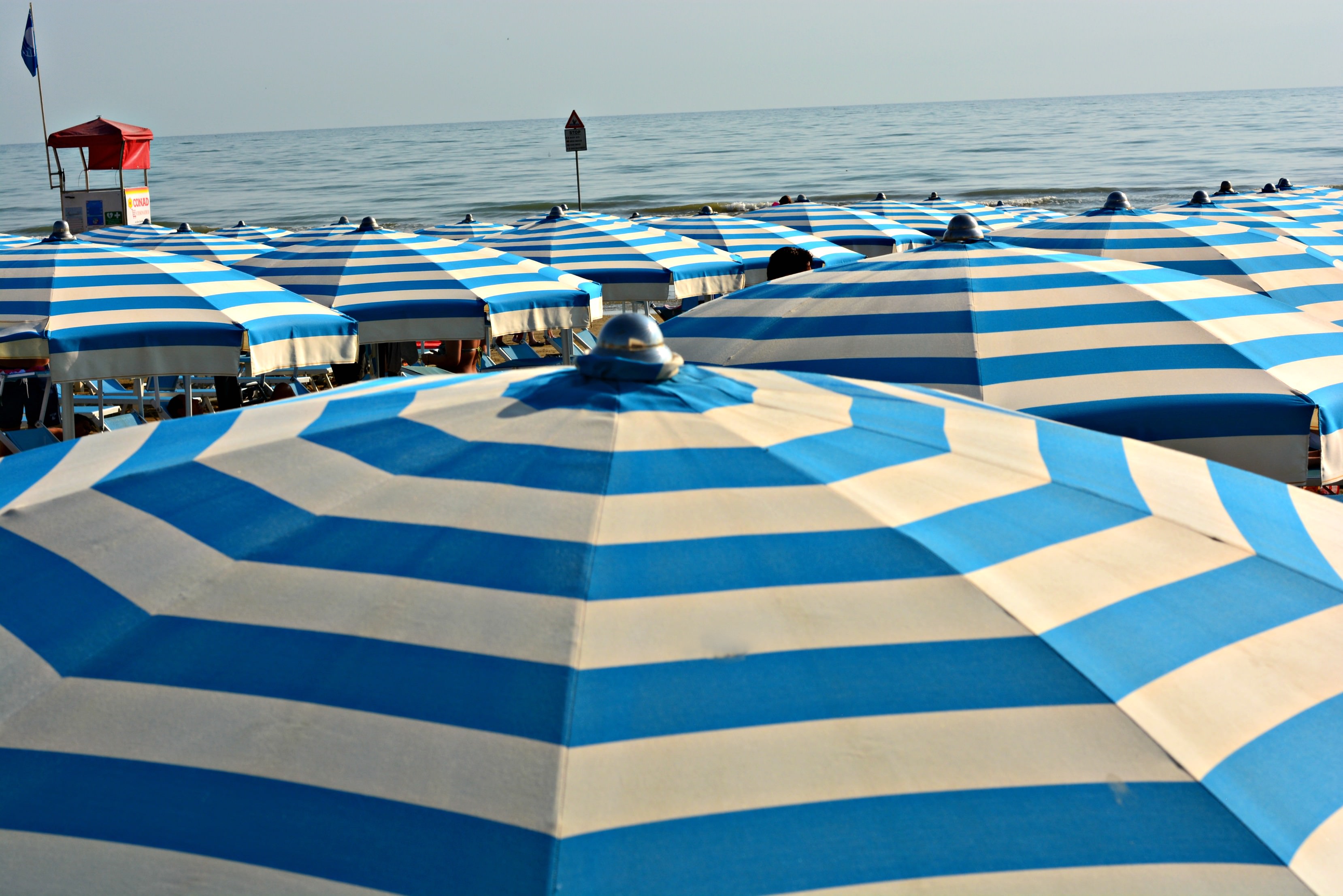 Why I keep going back to Italy | Fashion Food Travel - Over 40 | Blue striped beach umbrellas