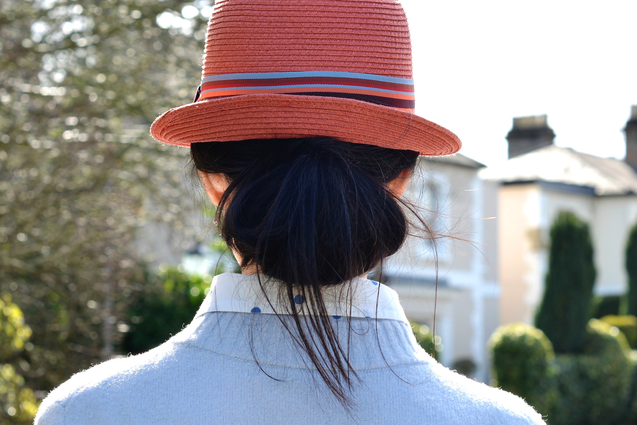 wear hair in a full low bun under trilby hat chic over 40