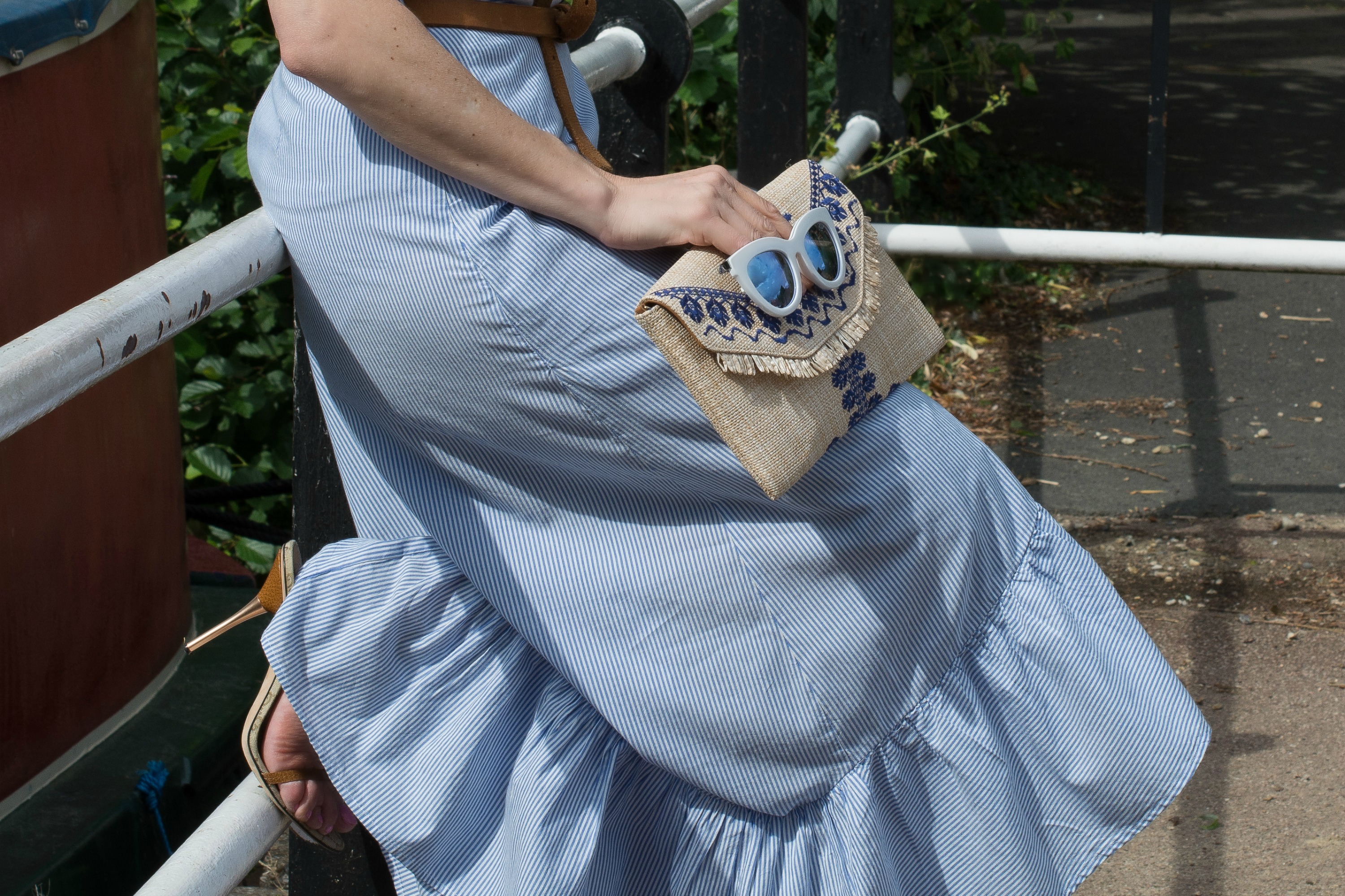 blue-pinstriped-cotton-skirt-raffia-clutch-bag